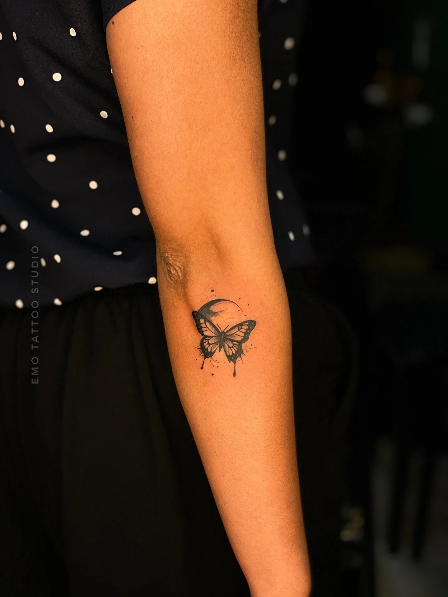 Delicate fine line butterfly tattoo on forearm