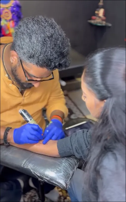 Arjun, lead tattoo artist focused on crafting a custom tattoo in the studio